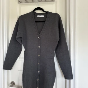 Grå stickad klänning - Fin grå stickad klänning från zara, figursydd med veck vid midjan, fint skick endast anvönd 1 gång