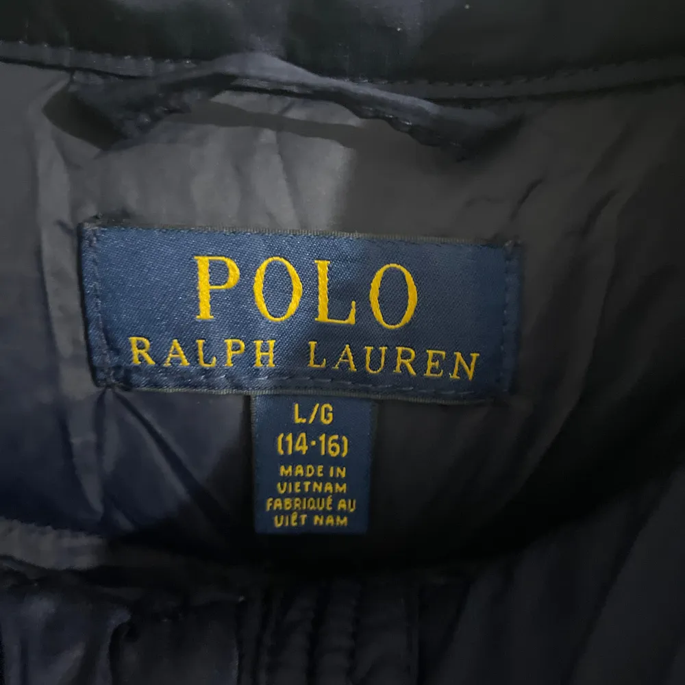 Säljer en snygg mörkblå dunväst från Polo Ralph Lauren. Västen har en dragkedja framtill och två praktiska fickor med dragkedjor. Perfekt för höst och vår när du vill hålla dig varm men ändå se stilren ut. Skicka gärna prisförslag . Jackor.