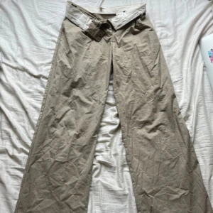 Beige chinos - Beiga byxor med nedvikbar kant. Använd fåtal gånger. Skriv privat för mer bilder/frågor!