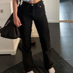 Svarta jeans från Weekday - Säljer ett par snygga svarta jeans från Weekday. De är högmidjade och har en bootcut/straight-stil som ger en riktigt schysst siluett. Perfekta för både vardag och fest! 🖤Modellen Rowe