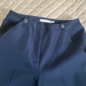 Exklusiva kostymbyxor från Tommy Hilfiger! - Exklusiva mörkblå kostymbyxor från Tommy Hilfiger! Storlek 2 vilket motsvarar ca xs. Knappt använd så Som nya!