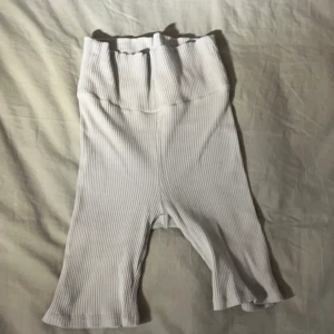 Vita ribbade byxor - Säljer ett par ljus gröna ribbade byxor. De är högmidjade och har en bekväm passform. Perfekta för en avslappnad stil eller gymmet.Man kan även vika dom så dom blir mid-low waist💗