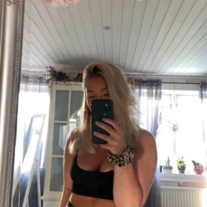 Svart ärmlös topp - Säljer en stilren svart ärmlös topp med smala axelband. Perfekt för sommardagar eller som en bas i garderoben. Toppen är enkel och kan matchas med nästan vad som helst!