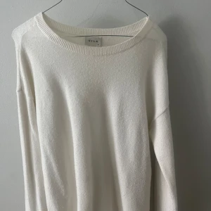 Vit stickad tröja - Tunn stickad vit tröja. Använda några gånger, är något lång neråt men går utmärkt att ha det så eller vika tröjan nere snyggt! Inte så jätte tjock i materialet men stickat! 