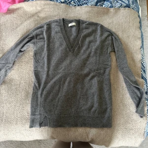 Grå kashmirtröja med v-ringning - Säljer en supermjuk och stilren grå kashmirtröja med v-ringning. Perfekt för både vardag och lite finare tillfällen. 