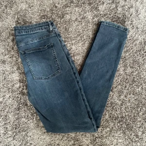 Mörkblå/grå ”Acne Studios” Jeans - Mörkblå/grå Acne Studios Jeans med passformen slimfit. Storlek 29 i midjan och 34 längd. Använda få gånger, men har ett litet hål på baksidan (kolla sista bilden). Dock så är det knappt synligt och allt annat är väldigt bra. Ny pris är 2000kr 😚.