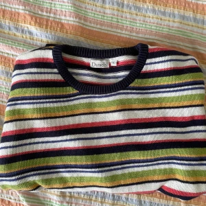 Randig tröja från Daniels - Säljer en färgglad randig tröja från Daniels i storlek L. Tröjan har ett mönster med ränder i blått, grönt, rött, vitt och svart. Den är långärmad och perfekt för en avslappnad stil. Passar bra till både jeans och chinos!