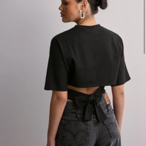 Open back tie tee nelly  - Säljer den här trendiga toppen från nelly pga fel storlek. Slutsåld och eftertraktad därav priset!💖💖 aldrig använd, endast testad