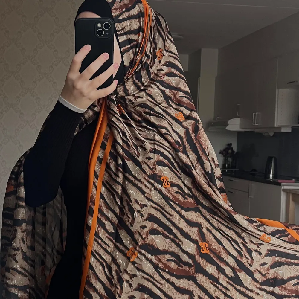 Snygg sjal med tigertryck i brunt och svart, detaljerad med orange inslag. Helt ny🛍️🤌🏻. Accessoarer.