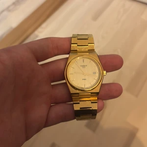 Tissot prx guld  - Säljer en elegant guldfärgad klocka från Tissot. Klockan har en stilren design med en metallarmband och en klassisk urtavla. Perfekt för både vardag och festliga tillfällen. Den är i mycket bra skick och använts ett få tal gånger. Låda finns och extra förlängningar. Nytt pris 4600