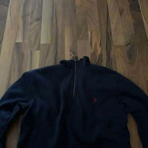 Mörkblå tröja från Polo Ralph Lauren - Säljer en snygg mörkblå tröja från Polo Ralph Lauren. Den har en halv dragkedja och det klassiska röda logotypbroderiet på bröstet. Perfekt för både vardag och lite finare tillfällen. Tröjan är i bra skick och passar perfekt till höst och vinter.