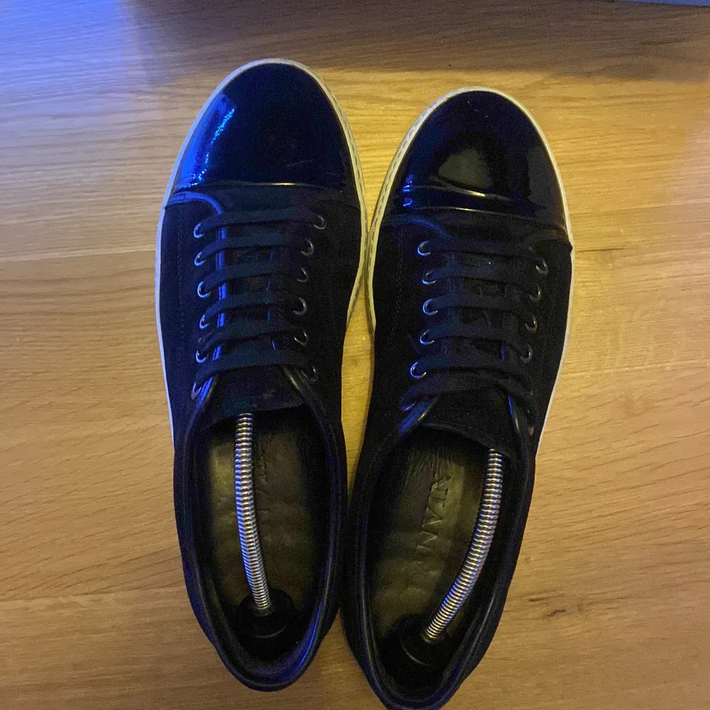 Säljer ett par snygga svarta sneakers från Lanvin i bra skick. De har en stilren design med svart mocka och vit sula. Dom passar 42/43 UK 8 . Skor.