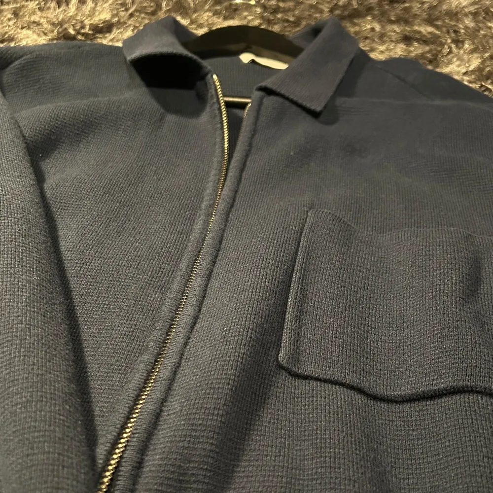 Säljer en stilren mörkblå overshirt med dragkedja framtill. skicket är 10/10 aldrig använt den förrut, i och med att den är för stor. priset är 449, bara skriva för fler frågor/bilder😀. Neuletakit & Villapaidat.