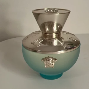 Dylan turquoise från Versace 100ml - Säljer en elegant parfymflaska från Versace med en lyxig design. Super fin doft. Man ser inte att parfymen är använd då den har används ett fåtal gånger. Den är i nyskick. Ordinarie pris: 900kr. Nypris: 600kr. Den är 100ml. Perfekt för den som vill ha en touch av glamour i sin parfymkollektion.