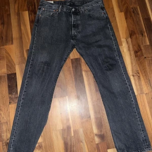 Svarta Levis 501 jeans - Säljer ett par klassiska svarta Levis 501 jeans i bra skick. De har en straight passform och är tillverkade i slitstarkt denim. Perfekta för både vardag och fest. Passar till allt och är ett måste i garderoben!