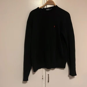 Svart stickad sweatshirt från Polo Ralph Lauren - Säljer en stilren svart sweatshirt från Polo Ralph Lauren i storlek S. Tröjan är i mycket bra skick och har en liten röd logga på bröstet. Perfekt för både höst och vinter med sin klassiska design och bekväma passform. Passar till alla tillfällen!