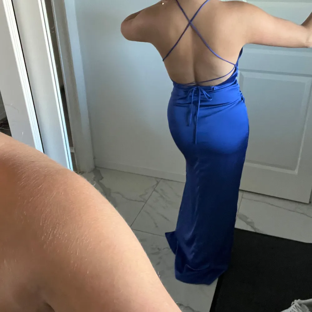 Säljer en elegant blå långklänning från Bubbleroom. Klänningen har en smickrande slits och korsade band i ryggen för en stilfull look. Perfekt för festliga tillfällen såsom bal och bröllop! 💙. Mekot.