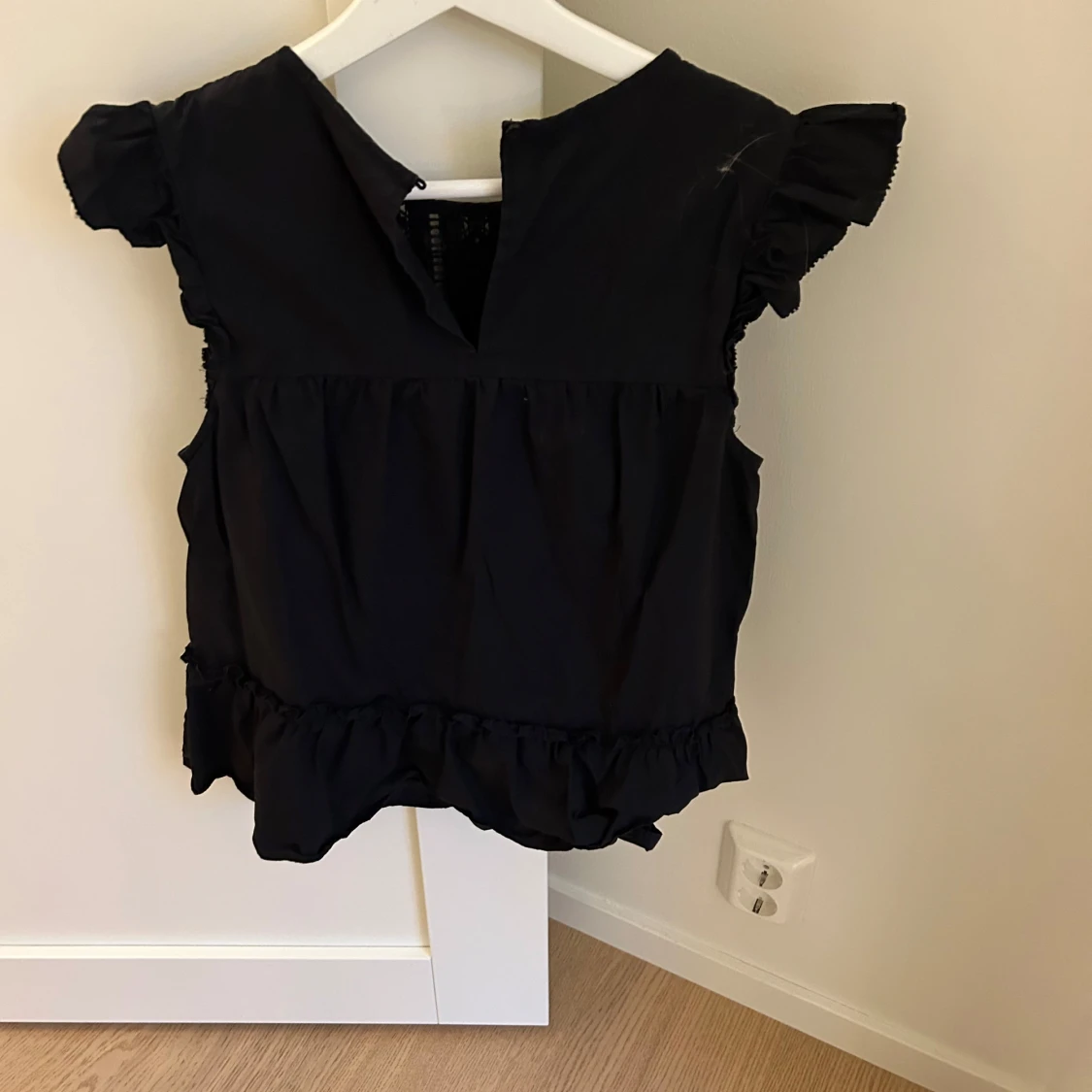 Svart blus med volangdetaljer - 90