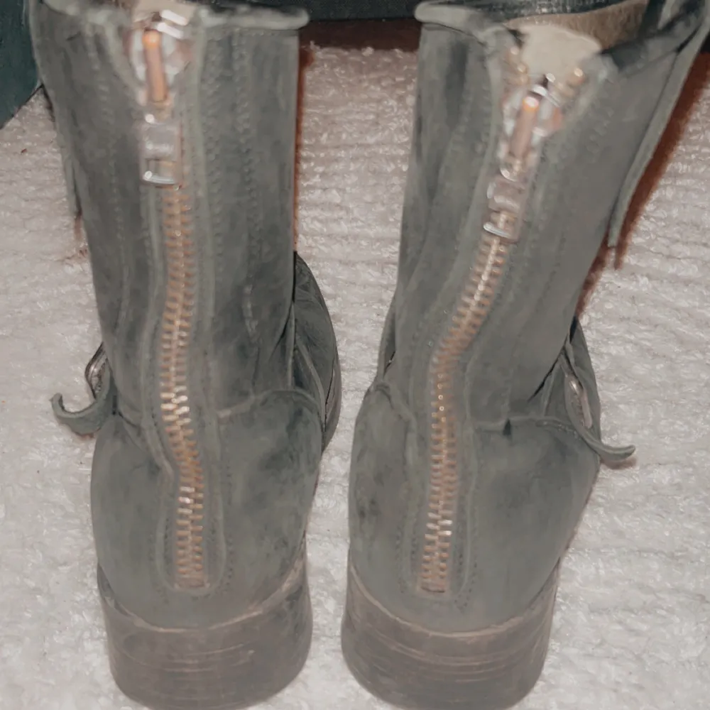 Säljer ett par svarta boots i skinn med coola detaljer som dragkedja bak och ett snyggt spänne på sidan. Perfekta för höst och vinter, de har en robust klack och är i bra skick. Passar både till vardags och lite tuffare outfits.. Skor.