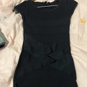 Svart klänning från Morgan - Snygg svart klänning från Morgan i storlek XS. Den har en tight passform och korta ärmar. Perfekt för festliga tillfällen med sin eleganta design. Klänningen är i mycket bra skick och redo att bäras till nästa event!