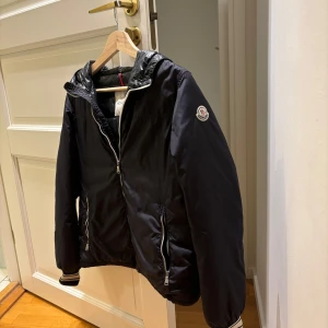 Blå jacka från Moncler - Säljer en moncler windbreaker för ett bra pris.  Jackan är i väldigt bra skick och har inga som helst tecken på andvändning. Killen på bilden är 174cm lång, vid någon som helst fundering är de bara att skriva, pris kan diskuteras 🙌!
