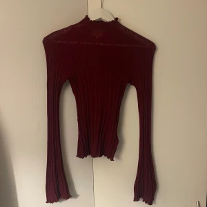 Vinröd ribbad tröja från H&M - Säljer en snygg vinröd ribbad tröja från H&M. Den har en hög krage och långa ärmar med vågiga kanter. Perfekt för höst och vinter, både stilren och bekväm. Passar bra till både jeans och kjol! 🍁🍁🍁