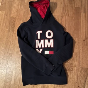 Tommy hillfigger hoddie - Säljer nu denna hoddie ifrån Tommy Hillfigger med tryck både fram och bak. Modellen på bilderna är ungefär 180cm lång. Hör av dig vid frågor eller fler bilder!