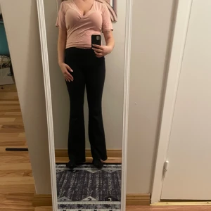 Rosa omlottopp - Säljer en söt rosa omlottopp med korta ärmar. Toppen har en v-ringad design och är tillverkad i ett mjukt material som ger en bekväm passform. Perfekt för en avslappnad stil.