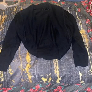 Svart bolerotopp - Säljer en  svart bolerotopp med långärmade ärmar. Står på etiketten L men alla vet 2000s L är dagens S, köpt secondhand men tycker de är för korta runt armarna så säljer vidare den 🖤