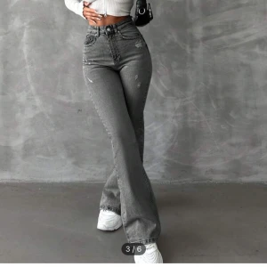 Grå bootcut jeans - Snygga grå bootcut jeans med hög midja och slitna detaljer. Perfekta för en trendig look. De har klassiska fem fickor och en knappgylf, helt oanvända. I storlek XS🩶.