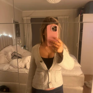 Beige kofta med knappar - Säljer en mysig beige kofta med knappar framtill. Perfekt för kyliga dagar och enkel att matcha med olika outfits. Koftan har långa ärmar och en klassisk design.