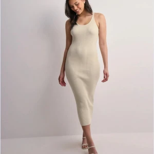 Beige ribbad klänning - Snygg beige ribbad klänning med en tight passform och ärmlös design. OANVÄND 
