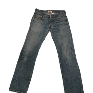 Levi's 501 jeans - Klassiska Levi's 501 jeans i blå denim med straight fit och knappgylf. Perfekta för en avslappnad stil. Dessa jeans har den ikoniska läderpatchen baktill och femficksdesign. Storlek W28 L30 passar nog perfekt för dig som är runt 175cm lång.