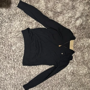 Blå Morris med liten dragkedja - Blå Morris tröja med dragkedja och liten logga på bröstet. Perfekt för hela året med sin stilrena design och bekväma passform. Nypris 1800kr