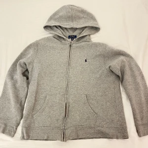 Grå hoodie från Polo Ralph Lauren  - Säljer den här gråa Ralph Lauren zip hooiden som är i storlek Xl i ungdomsstorlek. 