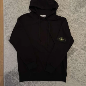 Svart hoodie från Stone Island - Snygg svart hoodie från Stone Island. 8/10 skick väldigt fräsch säljer pågrund av garderob rensning priset är inte hugget i sten känns dig jätte välkommen att diskutera om priset eller generellt andra frågor om tröjan 