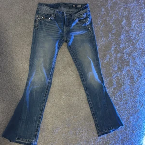 Miss me jeans bootcut - Snygga blå jeans från Miss Me med unika broderade detaljer och glittriga stenar på fickorna. Köpte dem skinny men gjorde om till bootcut! Innerbenslängd är 79. 