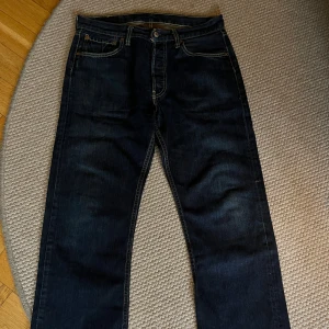 Mörkblå jeans från Levi's - Säljer ett par klassiska mörkblå Levi's 501 jeans. De har en rak passform och är tillverkade i slitstarkt. Använda ett fåtal gånger. Priset kan diskuteras vid snabb affär. Skriv vid fler bilder😃