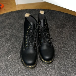 Svarta boots från Dr. Martens - Säljer ett par klassiska svarta Dr. Martens boots med snörning och gul söm runt sulan. Aldrig använt, kan vara lite damm på dem eftersom dem stått i garderoben de senaste 4 åren