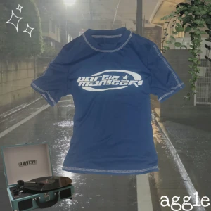 Y2K t shirt - Säljer en streetstyle blå t-shirt med ett coolt vitt tryck på framsidan. T-shirten harr kontrastsömmar som ger en unik look. 