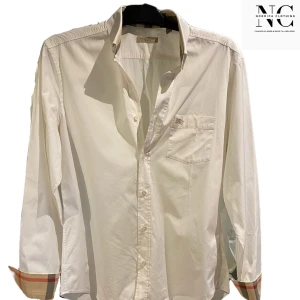 Vit skjorta från Burberry - Tja vi på Nordica Clothing säljer nu denna Snygga vita skjorta från Burberry Brit med klassisk krage och broderad logga på bröstfickan. Skjortan har långa ärmar med rutiga detaljer på insidan av manschetterna. Perfekt för en stilren look. Vid info/fler bilder tveka inte att höra av er. Priset kan diskuteras vid snabb affär.//skick 10/10//Nordica Clothing.