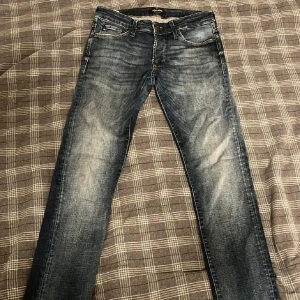 Jack & Jones slim glenn - Snygga blå jeans från Jack & Jones i modellen Slim/Glenn. De har en klassisk femficksdesign och en snygg tvättad look. Perfekta för en stilren vardagsoutfit.