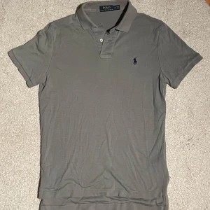 Ralph Lauren piké - Snygg pikétröja från Polo Ralph Lauren. Tröjan har korta ärmar och en klassisk krage med knappar. Den ikoniska loggan är broderad på bröstet. Perfekt för en stilren och avslappnad look.