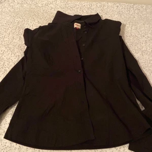 Svart skjorta från ONLY - Snygg svart skjorta från ONLY i storlek XL. Skjortan har långa ärmar och knappar framtill. Perfekt för en stilren look.