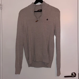 Beige tröja med dragkedja från Morris - Säljer en stilren beige tröja från Morris med dragkedja vid halsen. Tröjan har långa ärmar och ribbade muddar vid ärmslut och nederkant. Perfekt för en avslappnad och snygg look. Pris kan diskuteras.