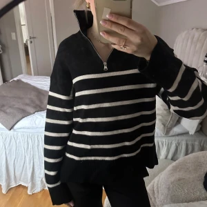 Svart/vit randig stickad tröja med dragkedja - Säljer en svart och vit randig tröja med dragkedja i halsen. Inköpt från zara men nu helt slutsåld! I nytt skick, endast använd enstaka gånger❣️Storlek S men passar även XS bra!