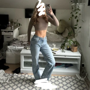 Blå jeans med bred passform - Snygga blå jeans med bred passform och medel-låg midja. De stängs med dragkedja och knapp. Perfekta för en avslappnad stil.