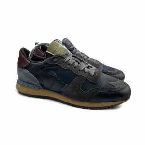 Valentino Rockrunner sneakers i flera färger - FRI FRAKT PÅ THEARCHIVE.SE | Snygga Valentino Rockrunner sneakers med en mix av färger som blå, grå och vinröd. Skorna har en unik design med snörning och en bekväm sula. Perfekta för dig som vill ha en stilren och modern look.                                                              Varumärke: Valentino Storlek: EU 43 Skick: BRA SKICK Material: Mocka/Läder Färg: Mörkblå Anmärkningar: kommer utan låda, lätt slitage Pris: 1799 SEK