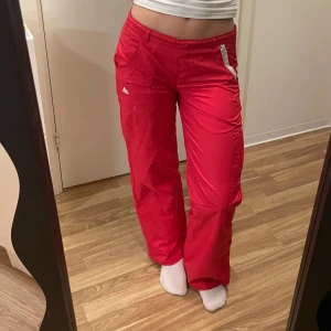 Röda träningsbyxor från Adidas - Snygga röda träningsbyxor från Adidas med vita detaljer. Jag är 160cm lång