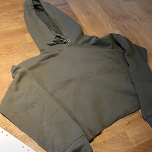 Grön hoodie från lager 157 - Säljer en grön hoodie från lager 157 i storlek    XS/S. Den har en klassisk design med huva och långa ärmar, den är även avklippt. Perfekt för en avslappnad stil. 🐢